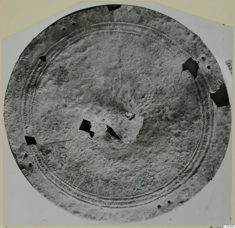 Round bronze disc, possibly a shield, with concentric ridged bands and holes around the rim, from Idalion