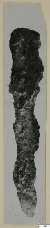 Corroded bronze knife from Idalion, photographed upright on a pale card mount