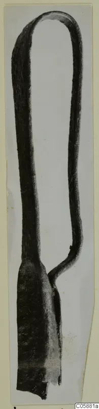 Bronze strigil from Idalion, a long curved metal object with a looped top and a flat broadened end.