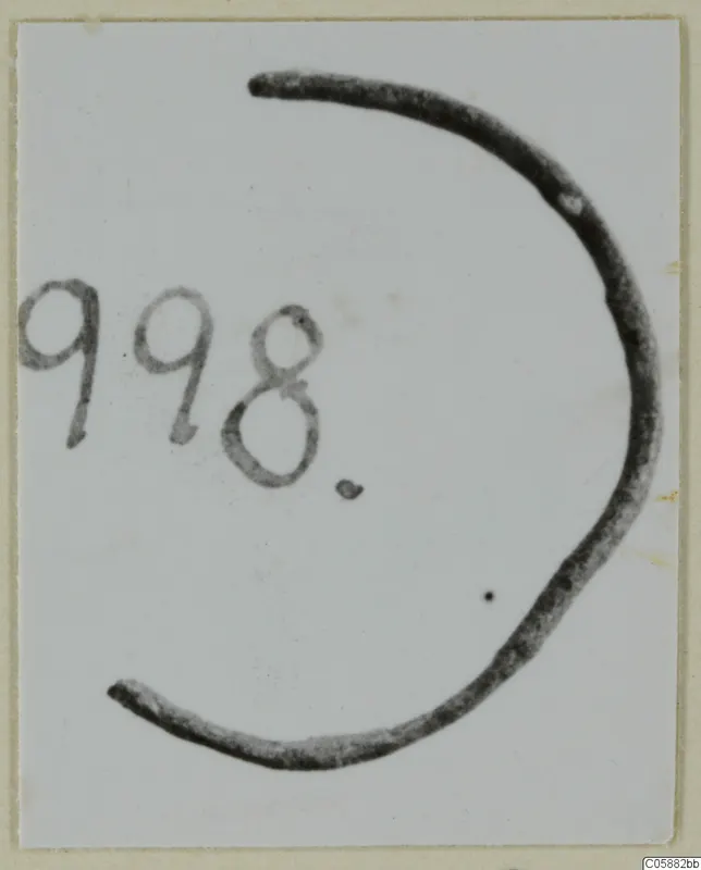 Fragment of a bronze ring from Idalion, photographed flat beside a handwritten number label