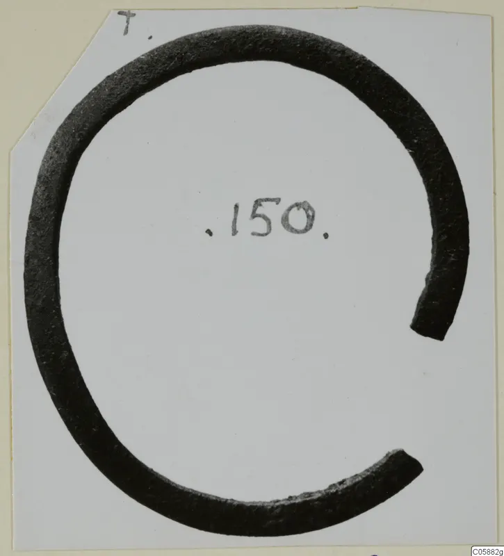 Open bracelet of dark metal with a wide gap, photographed on a white card