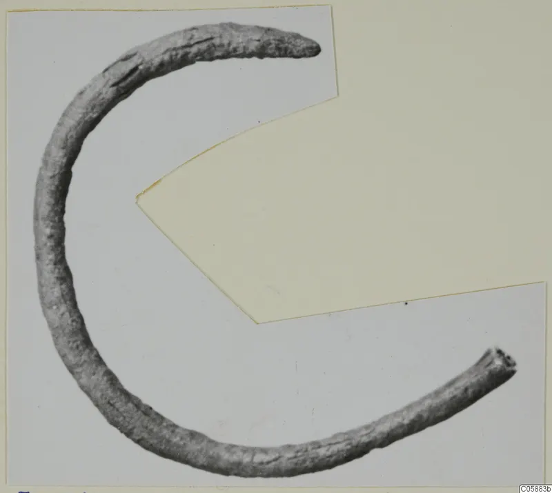 Bronze personal adornment fragment from Idalion, a curved bronze rod with tapered ends.