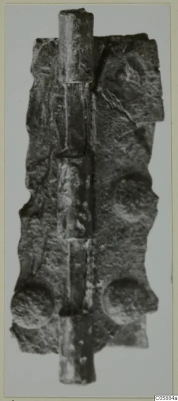 Corroded bronze hinge with a long vertical pin running through its flat plate