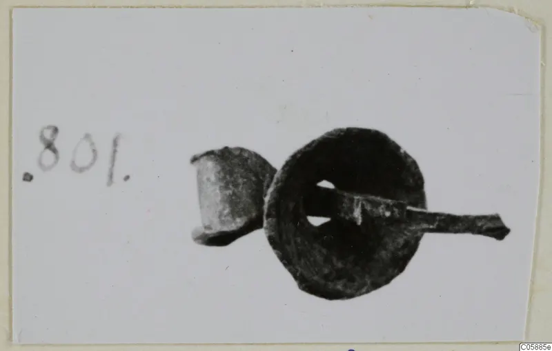 Bronze mounting fragments: a corroded disc with a rod passing through its central hole, and a small socket piece