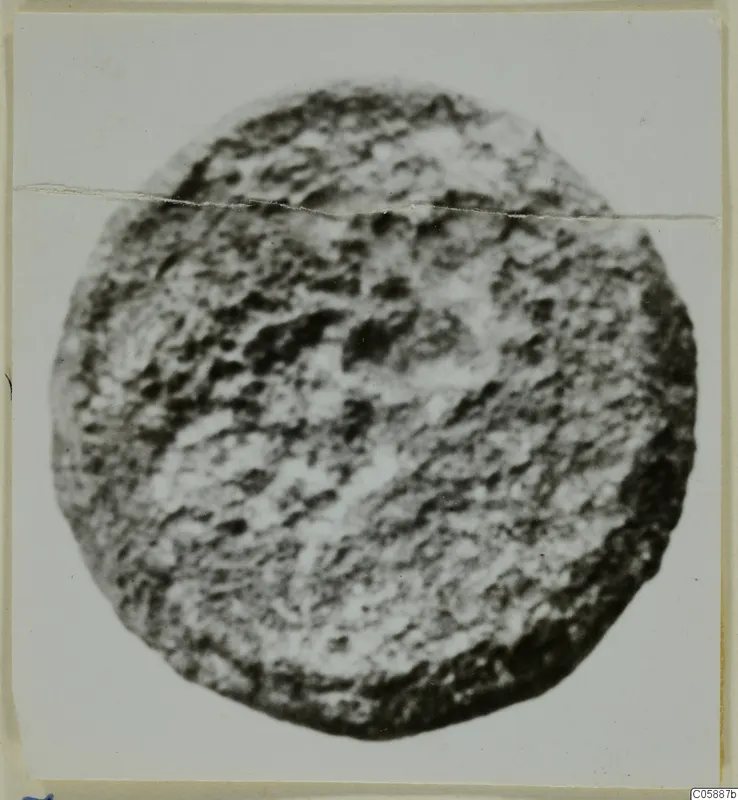 Round lead object, heavily corroded, photographed face-on against a pale background.