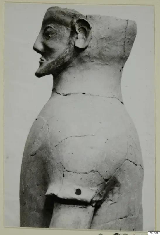 Terracotta figure in side profile with a long nose, pointed beard and flat-topped head