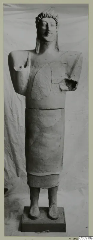 Terracotta standing figure with a band of rounded curls on the head, arms broken, set on a rectangular base