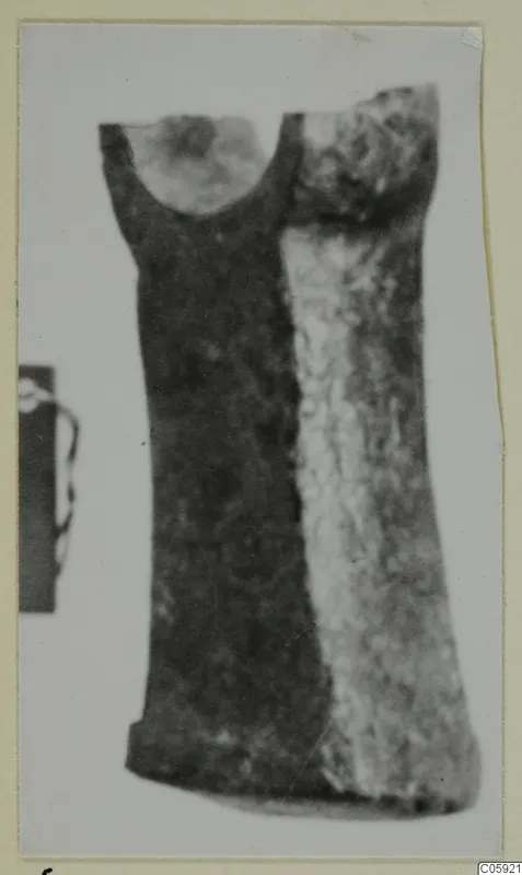 Bronze tool from Idalion with a rounded socket at its upper end, shown in a photograph on a card mount