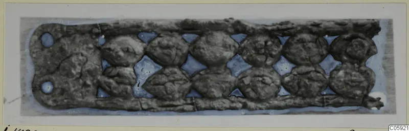 Bronze horse-trappings from Idalion: a corroded rectangular strip with two rows of round bosses and diamond-shaped openings
