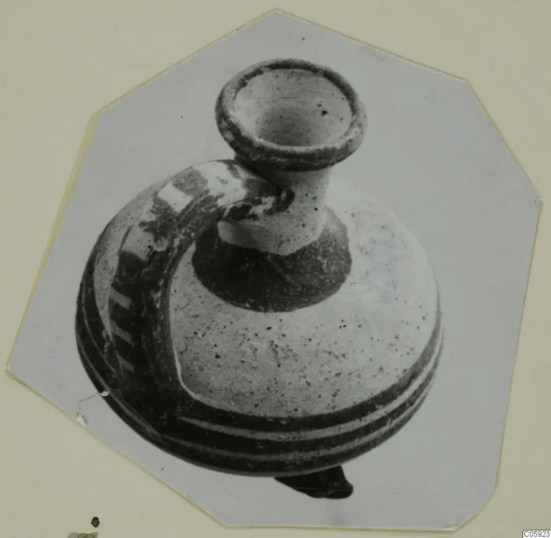 Pottery White Painted II vessel with a flaring rim, short neck and strap handle, shown on a card mount