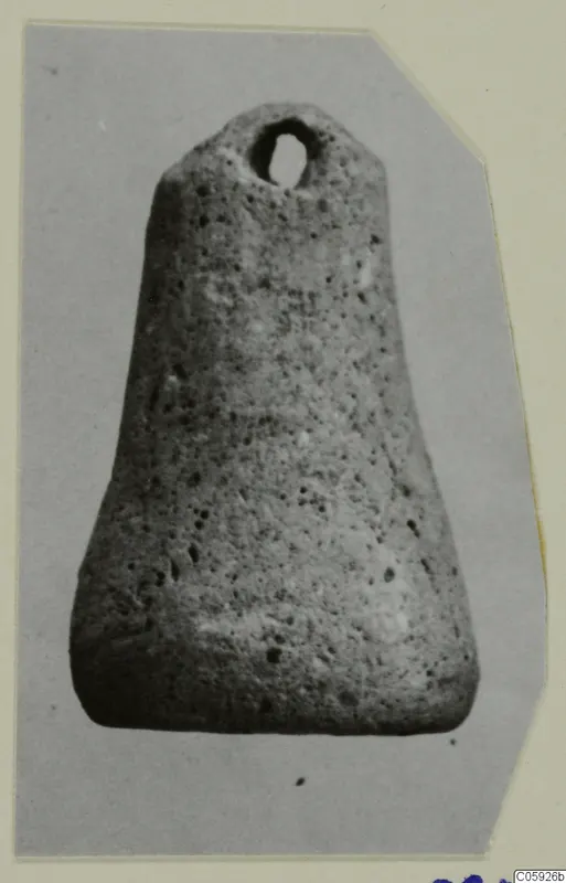 Pierced porous stone object, tapering toward the base, with a suspension hole near the top