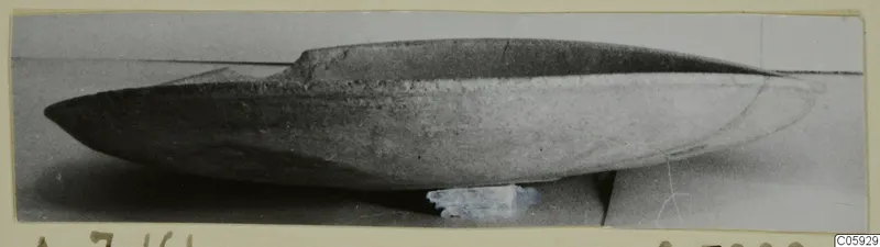Shallow pottery plate from Amathus, shown in side view on a plain grey surface