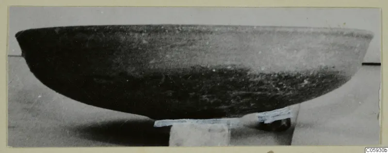 Side view of a shallow pottery bowl from Amathus tombs, resting on a small block.