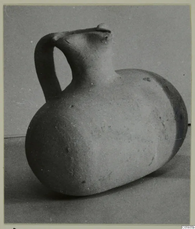Pottery Plain White vessel with a tall strap handle and pinched spout, lying on its side
