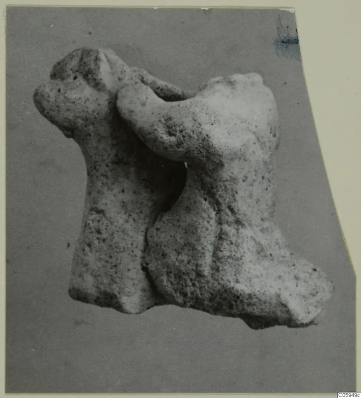 Terracotta minor plastic animal figurine, pale and porous, shown on a grey card mount
