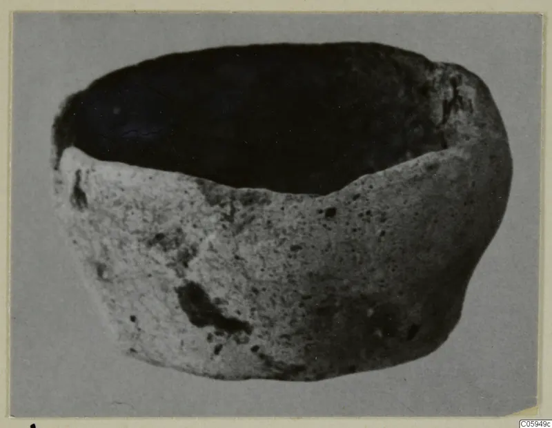 Terracotta lamp, a rounded open vessel with a dark interior, shown on a grey background