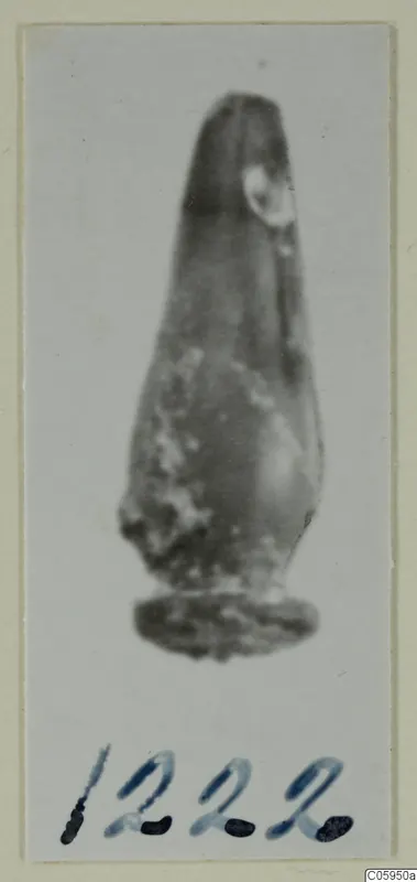 Small find from Idalion: a tapering pendant with a flat base, shown on a card mount