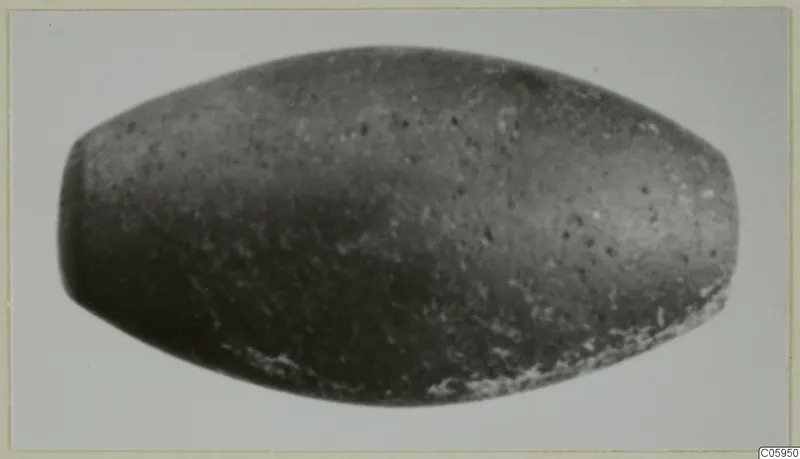 Elongated barrel-shaped bead from Idalion, dark grey with pale speckles.