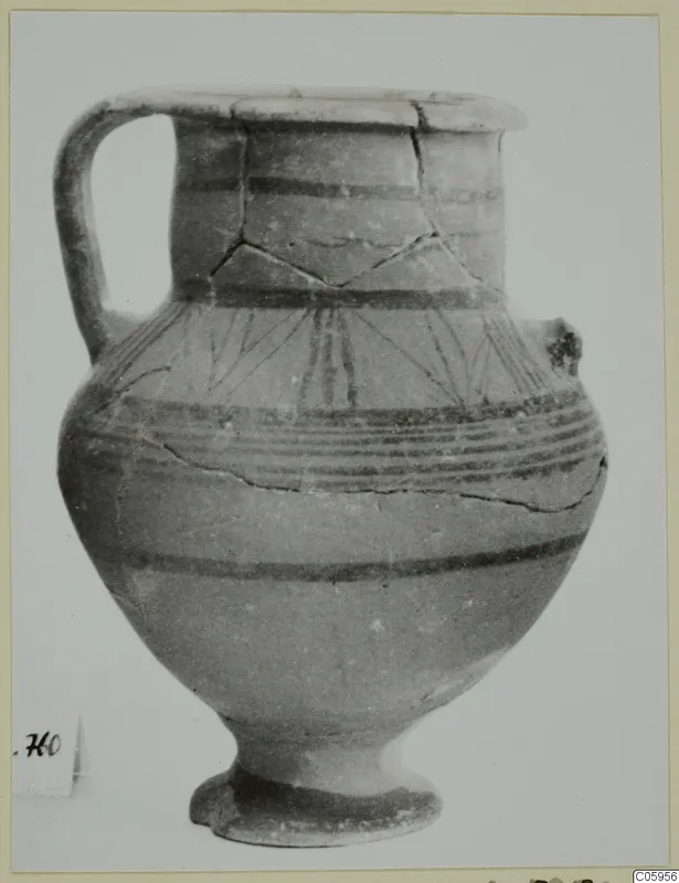 Pottery Black-on-Red jug with a single handle, dark painted bands and fanned lines on the shoulder