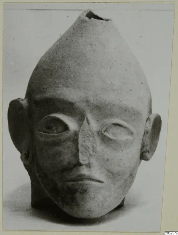 Terracotta head with a tapering top, a ragged opening at the crown, and large almond-shaped eyes; Terracotta Proto-Cypriote I