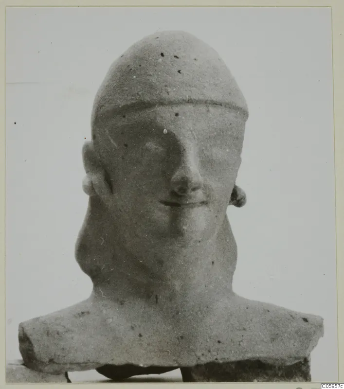 Terracotta bust of a man with a high rounded cap, photographed head-on against a plain background
