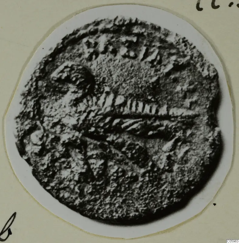 Coin from Idalion with raised central design, shown enlarged on a white circular card mount