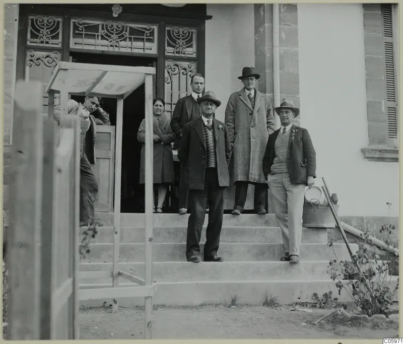 Group of six men and a woman posed on the steps of a building at Omologitades, Nicosia