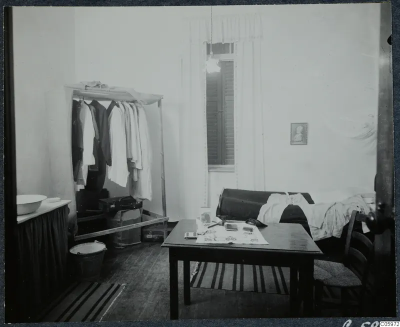Room of Johns Lindros and Eriks Sjöqvist in Nicosia, with clothes hanging on a rack and a table by the window.