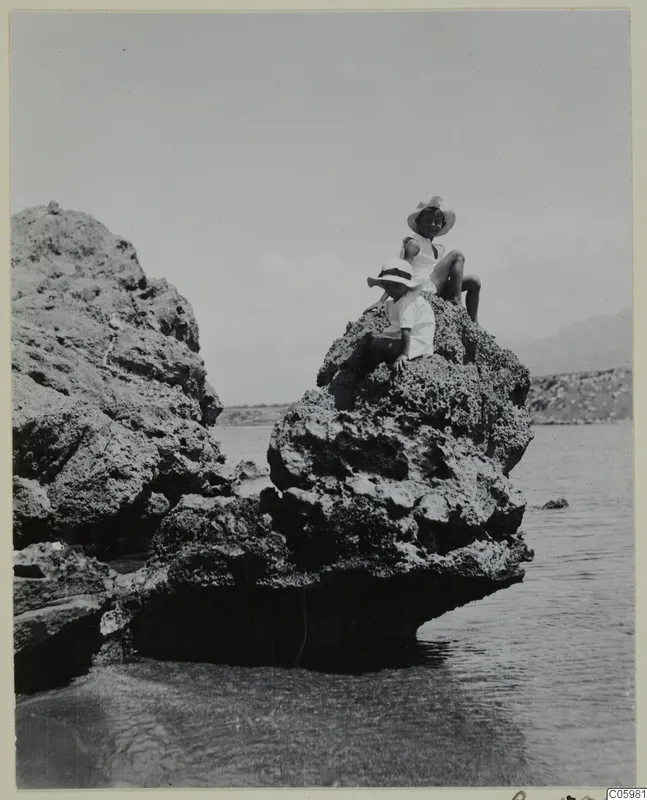 Two children sitting on a rocky outcrop above the sea at Kyrenia