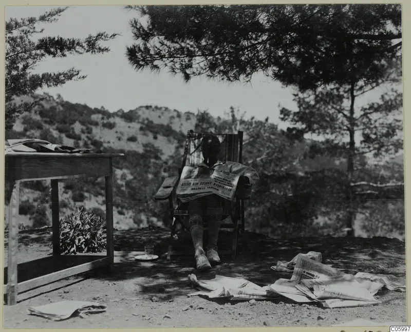 Einar Gjerstad reading newspapers in a deck chair on a terrace at Machairas.
