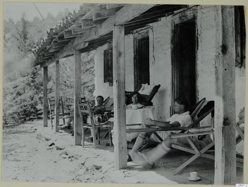 People resting in deck chairs on the terrace of a whitewashed house at Machairas.