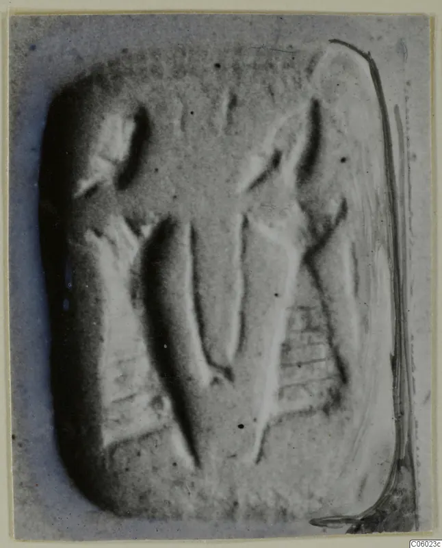 Engraved stone seal with rounded corners, showing carved figures in relief, photographed close up.