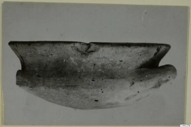 Pottery sherd of Grey Polished Ware from Idalion, shown in side view against a plain grey background
