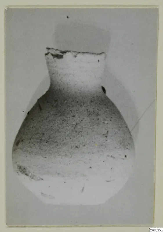 Pottery Plain White IV-V jug from Idalion with a broken rim, photographed against a grey background