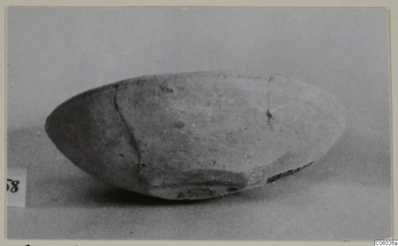 Plain white pottery bowl with a diagonal crack, photographed in side view against a grey backdrop.