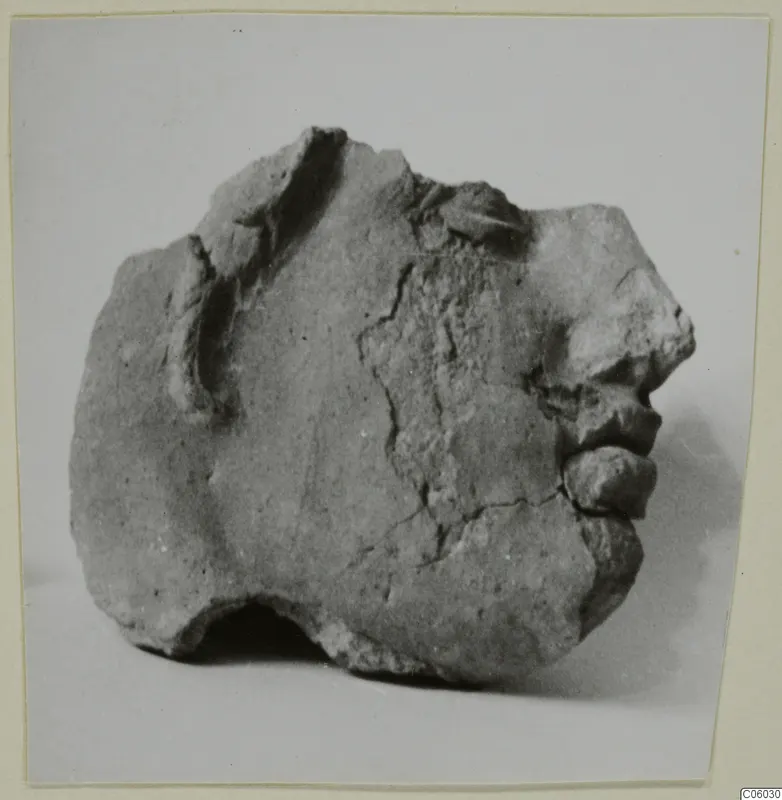 Fragment of a head from Mersinaki, showing nose, lips and chin in profile, with a broken and chipped surface.