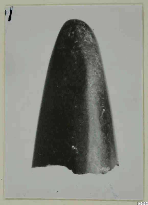 Single worked object with a rounded tip and a broken base, shown upright on a pale background