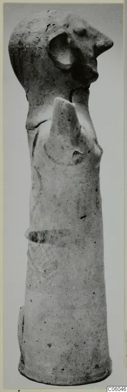 Terracotta figurine from Ayia Irini with a head bearing a large round ear and a tall, tapering cylindrical body