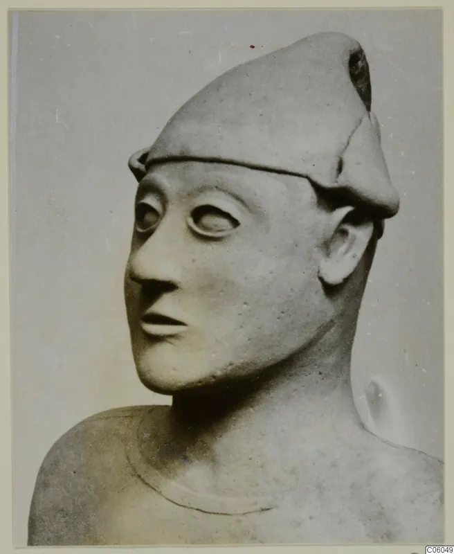 Terracotta Proto-Cypriote II: head and shoulders of a figure wearing a tall cap, large eyes and a long nose