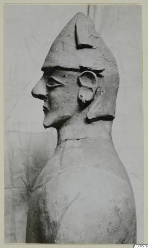 Terracotta Proto-Cypriote I: head and upper body of a figure seen in profile, wearing a tall pointed cap.