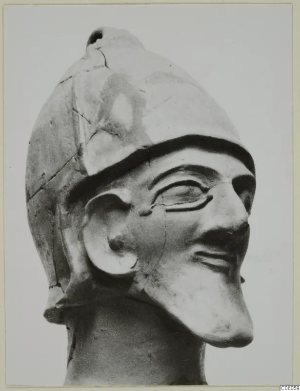Terracotta Proto-Cypriote II, a head of a figure wearing a helmet, shown in three-quarter view