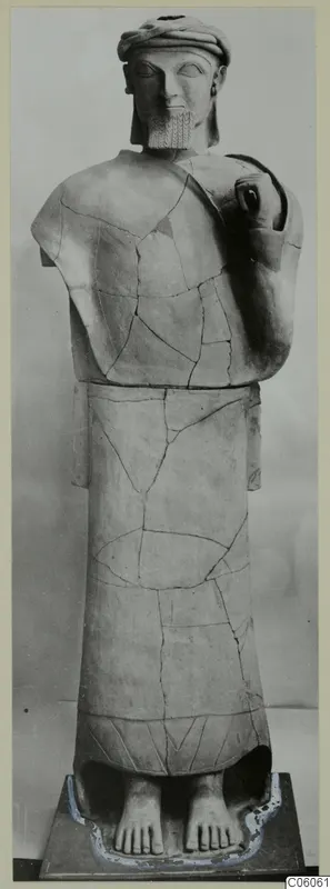Terracotta statue of a standing bearded figure, Proto-Cypriote II, reassembled from fragments and shown on a dark plinth