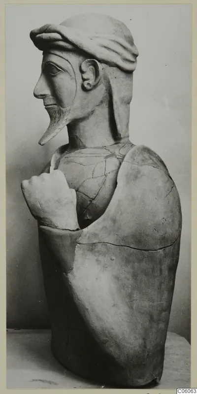 Terracotta Proto-Cypriote II, a bearded head and upper body in profile, one hand raised to the chest