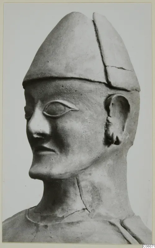 Terracotta Proto-Cypriote I: a statue head and neck in three-quarter view, wearing a tall conical cap