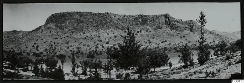 Flat-topped rock ridge at Fylleri, Kythrea, with scrub trees and a stretch of water below it