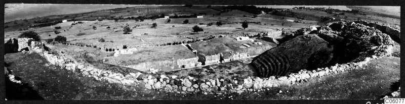The theatre at Soli, seen from above with a curved stone wall, tiered seating and open fields beyond.