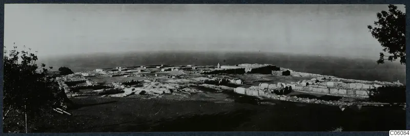 The palace at Vouni seen from the south, with low walls of ruined rooms spreading across a hilltop above the sea.