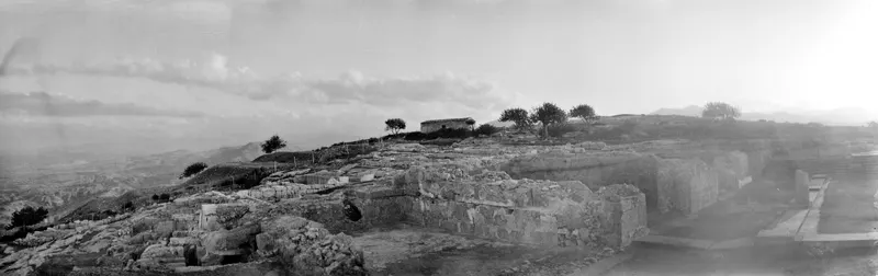 View across the palace ruins at Vouni towards the summit, with stone walls, trees and hills beyond