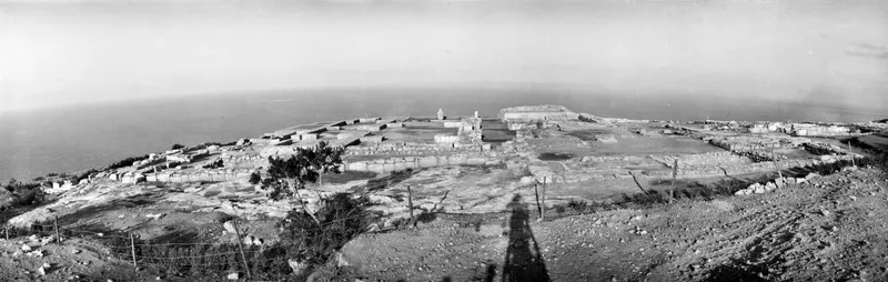 Ruins of the palace at Vouni on a coastal headland, seen from the south-west, with the sea beyond.