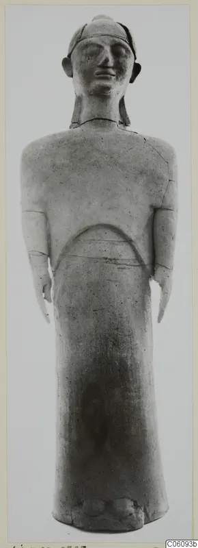 Standing terracotta figure from Ayia Irini, shown frontally against a grey backdrop